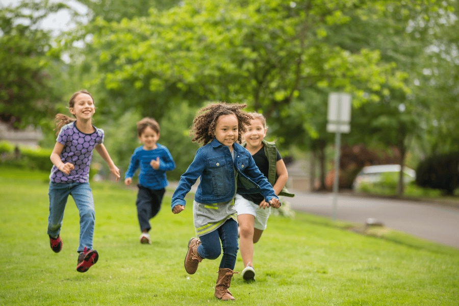 kids playing together running and laughing through the neighborhood